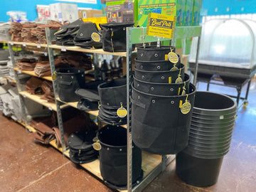 BudPots fabric grow pots displayed in retail store showing rigid rim structure, aluminum LST grommets and stacked 3 gallon training pots for cannabis growers
