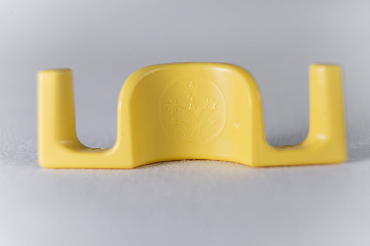 One yellow BudClip on its own, showing the wide mouth and the two arms that grip the stem.