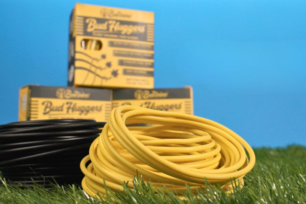 A yellow and a black BudHuggers coil side by side with their cartons behind them.