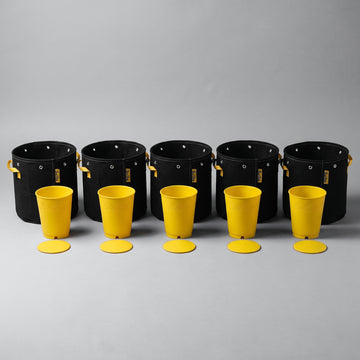 Five black BudPots fabric grow bags in a row, each with a yellow BudCups nursery pot and its removable bottom plate in front of it, on a plain grey background.