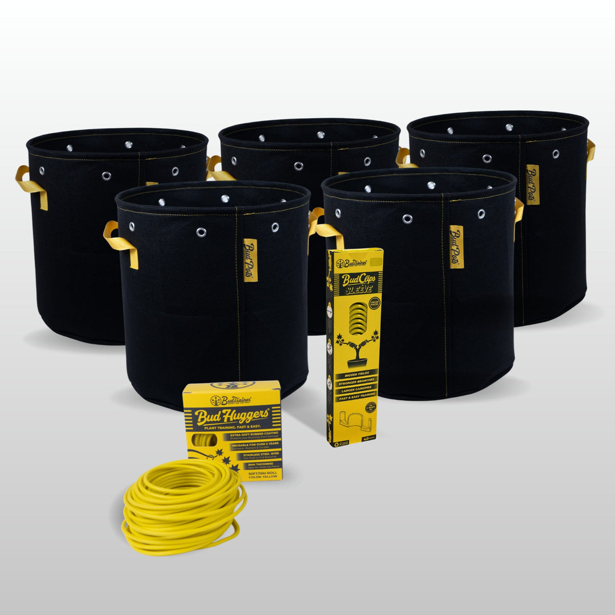 The Training Kit for a 2x2 ft tent laid out on a pale grey background: five black BudPots fabric grow bags with yellow handles behind, a yellow BudClips Sleeve 40-pack carton, a yellow Bud Huggers carton and a coiled 50 ft roll of yellow BudHuggers garden wire in front.